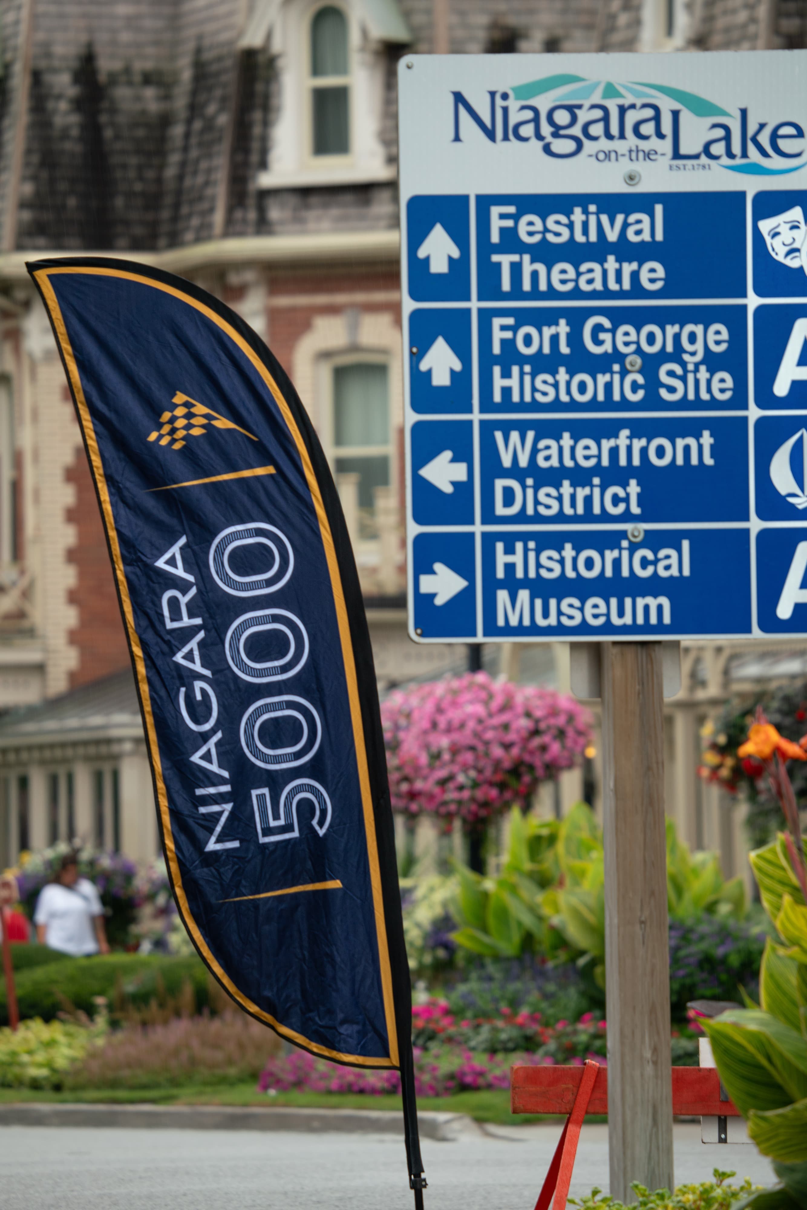 Niagara 5000 feather flag beside a Niagara-on-the-Lake wayfinding sign