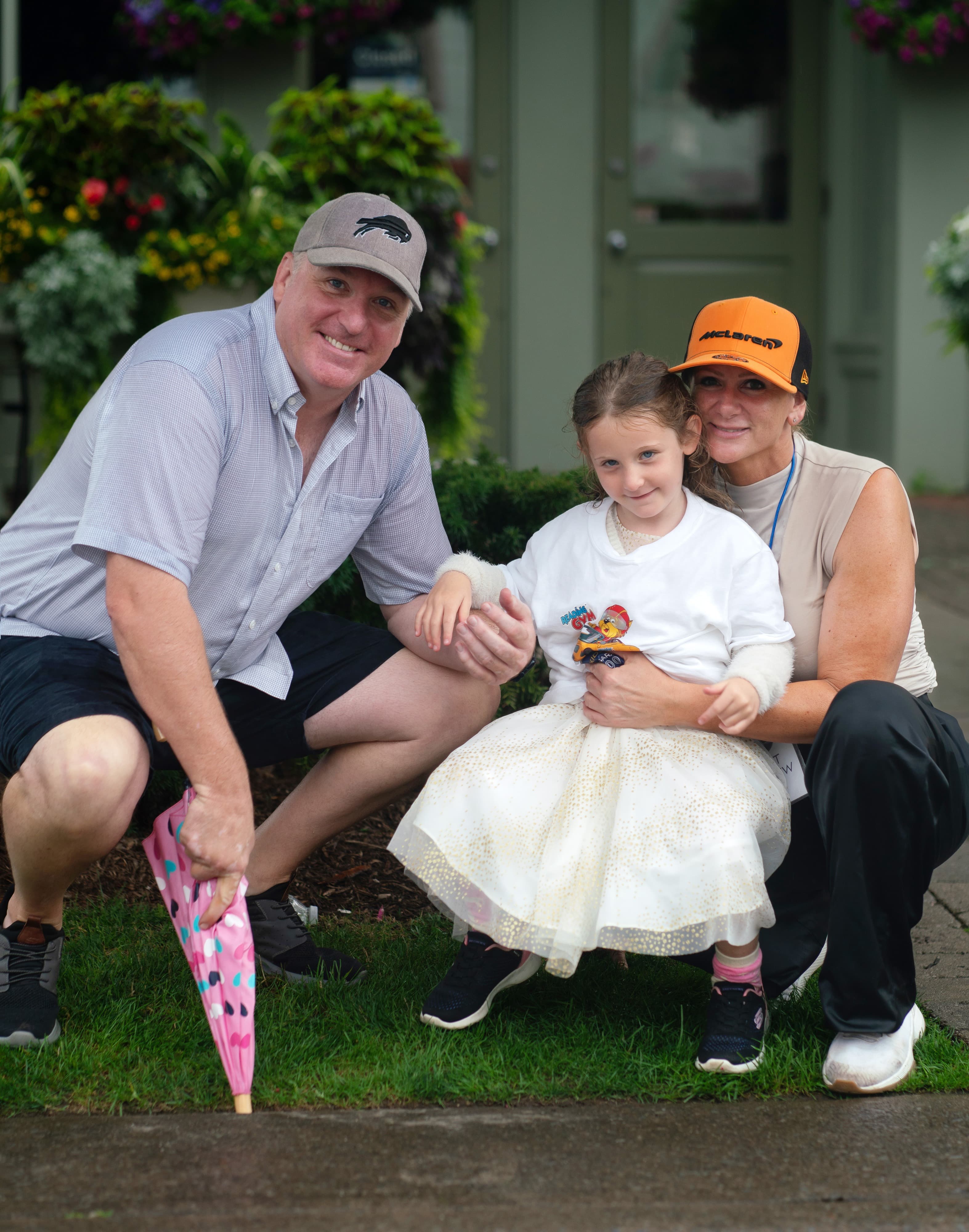 Family with a young girl poses on the lawn outside an event venue